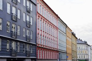 fire bygårder i Oslo på en rekke, en blå, rosa, lyseblå, oransje og gul